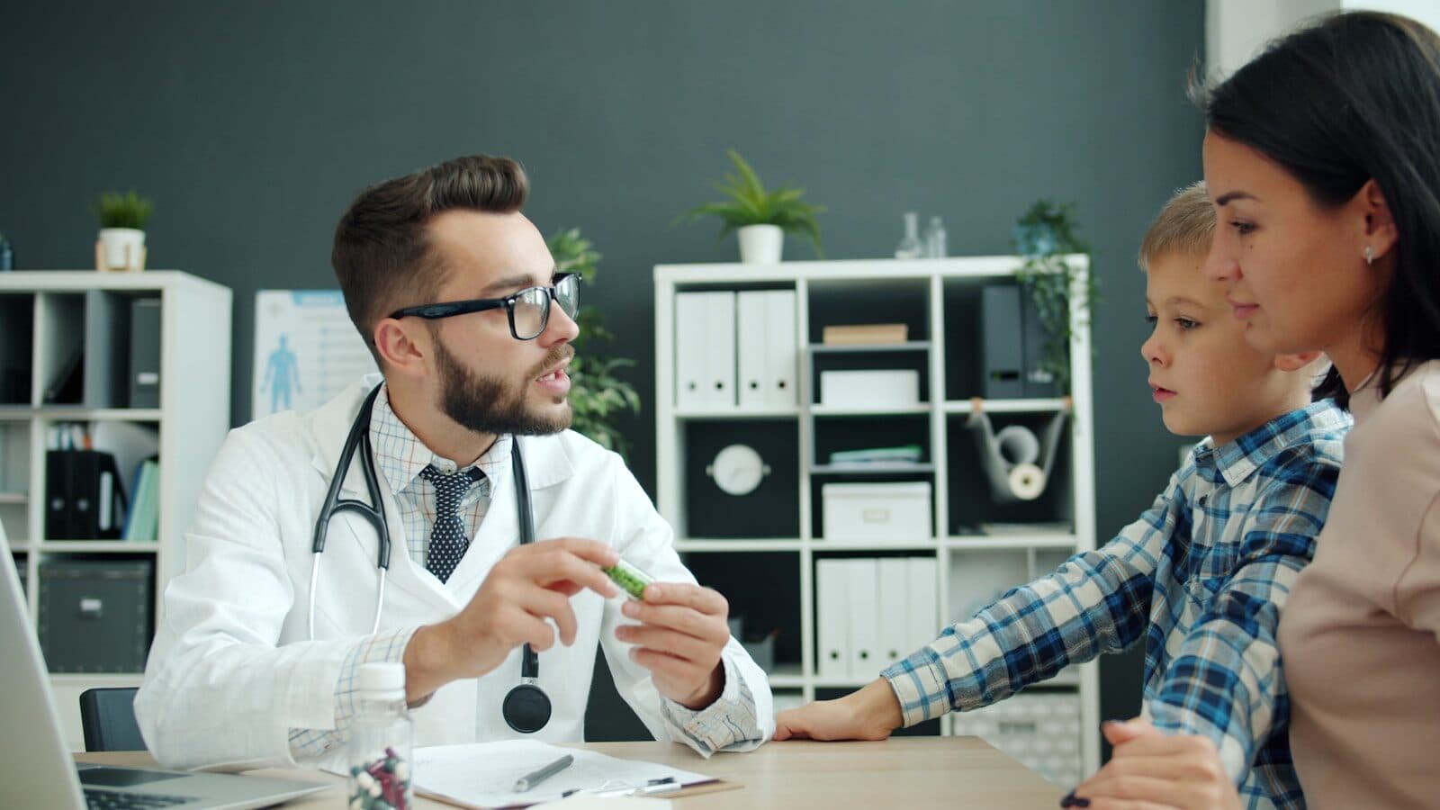 Doctor talks to mother and son in office.
